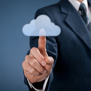 A businessman is pointing at a cloud icon on a blue background.