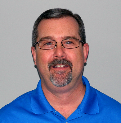 A man with glasses and a beard wearing blue.